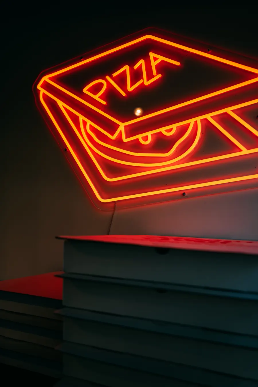 The neon pizza box sign glowing at Mama Said Pizza Co.